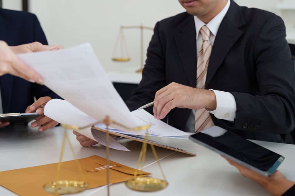 Legal and professional support for Vanuatu citizenship applications|瓦努阿圖法律服務 Reviewing legal documents and due diligence paperwork in a professional advisory setting — 法律支援